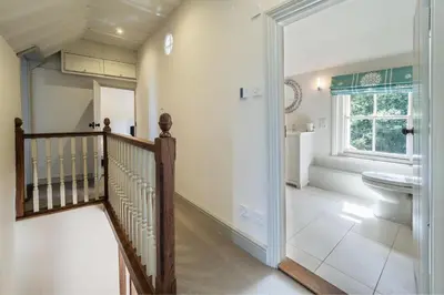 a bathroom with a staircase and a toilet and a window at Alexander House 6 in Thorpeness