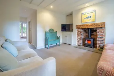 a living room with a couch and a fireplace at Alexander House 6 in Thorpeness