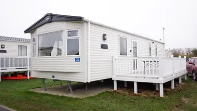 a white tiny house on display in a yard at Excellent caravan 2 bedrooms sleeps 6 in East Mersea