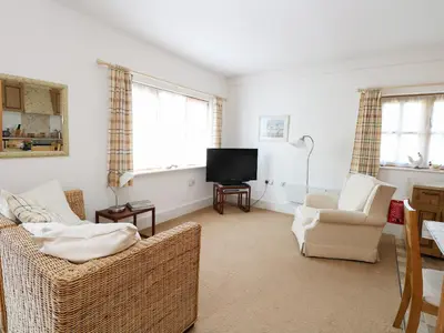 a living room with two chairs and a flat screen tv at Flink's Barn in Great Dunmow