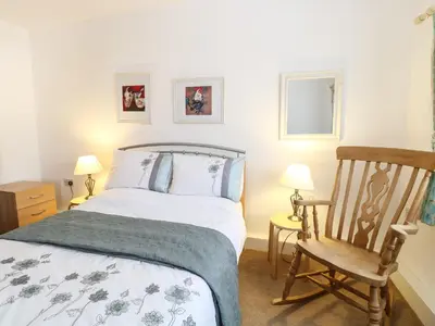 a bedroom with a bed and a rocking chair at Flink's Barn in Great Dunmow