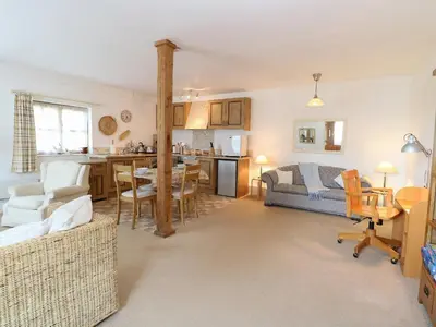 a living room with a couch and a table at Flink's Barn in Great Dunmow