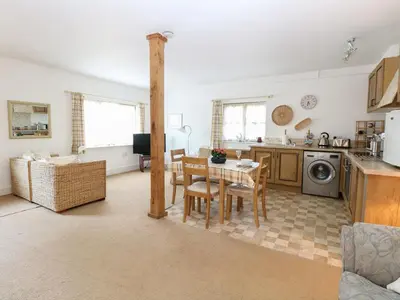 a kitchen and living room with a table and chairs at Flink's Barn in Great Dunmow