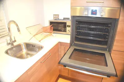 a kitchen with a sink and an open oven at 360 Serviced Accommodations - Brentwood 2 Bedroom Executive Apartment with Secure Parking in Brentwood