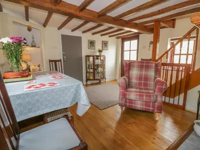 a living room with a table and two chairs at Rose Cottage in Ipswich