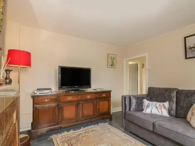 a living room with a couch and a flat screen tv at Rose Cottage in Ipswich