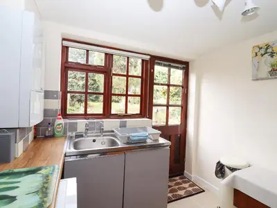 a kitchen with a sink and two windows at Rose Cottage in Ipswich