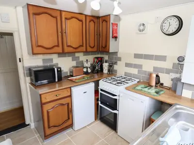 a small kitchen with a stove and a microwave at Rose Cottage in Ipswich
