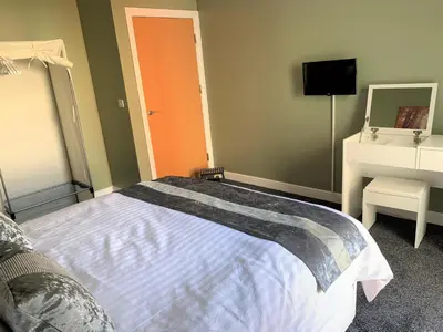 a bedroom with a bed and a sink and a mirror at Toothbrush Apartments - Central Ipswich - Nr Train Station in Ipswich