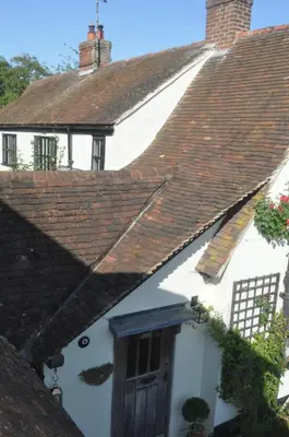 a white house with a snowman face on the roof at Chequer Cottage in Horseheath