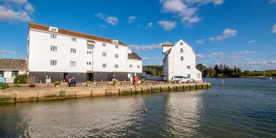 a large white building next to a body of water at The Station Guest House in Woodbridge