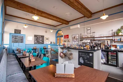a restaurant with wooden tables and a bar at The Station Guest House in Woodbridge