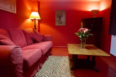 a red living room with a couch and a table at Stunning Apartment with Courtyard Near The Waterfront Ipswich in Ipswich