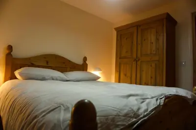 a person sitting on a bed in a bedroom at Stunning Apartment with Courtyard Near The Waterfront Ipswich in Ipswich