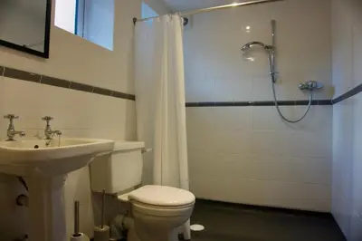 a bathroom with a toilet and a shower and a sink at Stunning Apartment with Courtyard Near The Waterfront Ipswich in Ipswich
