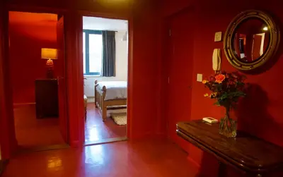 a red room with a mirror and a bedroom at Stunning Apartment with Courtyard Near The Waterfront Ipswich in Ipswich