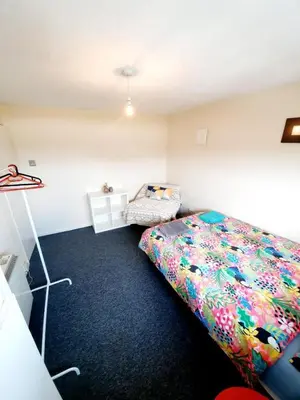 a bedroom with a bed with a colorful comforter at Rayleigh Town Centre 3 Bedroom Apartment in Rayleigh