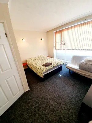 a hotel room with two beds and a window at Rayleigh Town Centre 3 Bedroom Apartment in Rayleigh