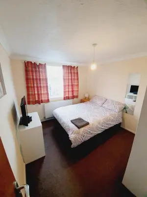 a small bedroom with a bed and a window at 4 Bedroom Thundersley Apartment in Rayleigh