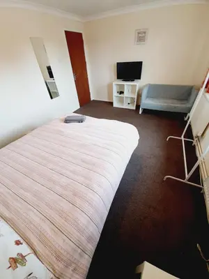 a hotel room with a bed and a television at 4 Bedroom Thundersley Apartment in Rayleigh