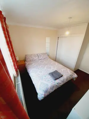 a small bedroom with a bed and a window at 4 Bedroom Thundersley Apartment in Rayleigh