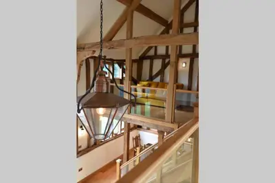 a chandelier hangs from the ceiling of a room at Old Oak Barn - Beautiful barn conversion with wonderful Jacuzzi hot tub in Stowmarket
