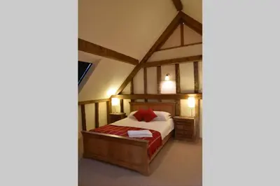 a bedroom with a bed in a room at Old Oak Barn - Beautiful barn conversion with wonderful Jacuzzi hot tub in Stowmarket