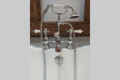 a shower in a bathroom with a shower head at Old Oak Barn - Beautiful barn conversion with wonderful Jacuzzi hot tub in Stowmarket