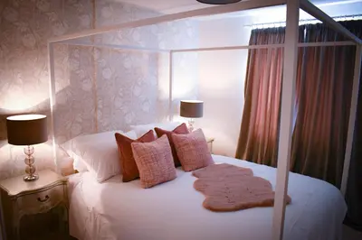 a bedroom with a large white bed with pillows at The Gate Cottage in Thaxted