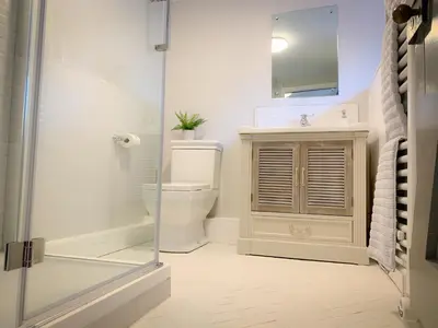a bathroom with a toilet and a glass shower at The Gate Cottage in Thaxted