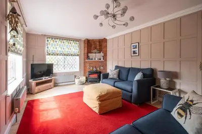 a living room with a blue couch and a tv at 1 Westgate in Thorpeness