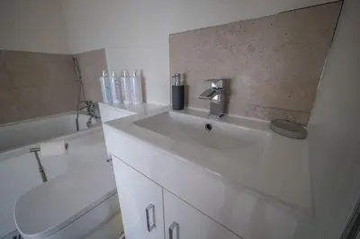 a white bathroom with a sink and a toilet at The Stables in Halesworth