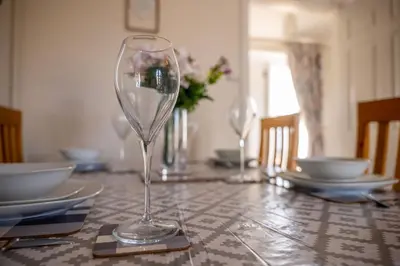 a table with two wine glasses on top of it at The Stables in Halesworth