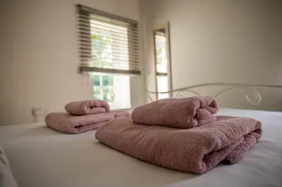 three towels sitting on top of a bed at The Stables in Halesworth