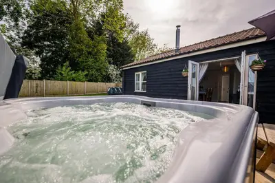 a hot tub in the backyard of a house at The Stables in Halesworth