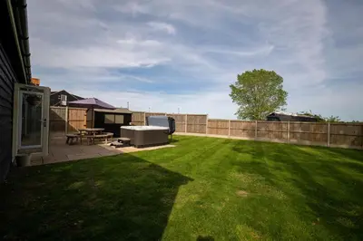 a backyard with a picnic table and a fence at The Stables in Halesworth