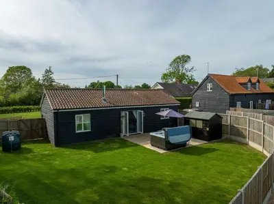 a small yard with a house and a fence at The Stables in Halesworth