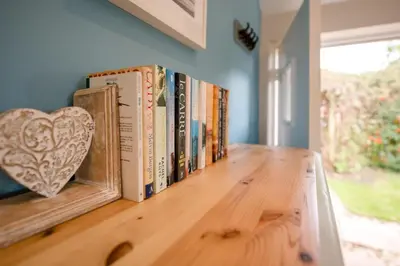 a row of books on a shelf in a room at Little House, Aldringham in Leiston