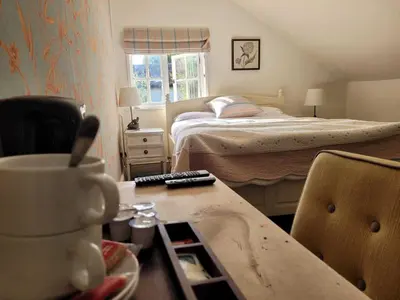 a small bedroom with a bed and a desk with a table at Three Tuns Ashwell in Ashwell