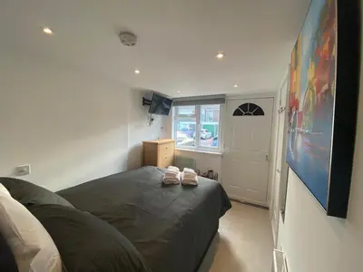 a bedroom with a bed with two shoes on it at Comfortable cosy double ensuite room 'Karibu' in Cherry Hinton