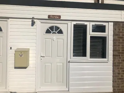 a white garage with a door and a window at Comfortable cosy double ensuite room 'Karibu' in Cherry Hinton