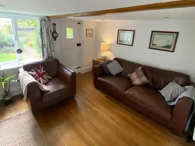 a living room with two brown leather couches at Honey Cottage in Friston