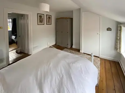 a bedroom with a large white bed in it at Honey Cottage in Friston