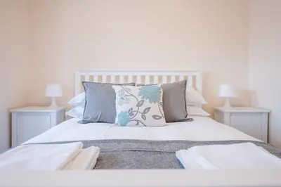 a bedroom with a white bed with pillows at 2 Abbey Mews, Leiston in Leiston