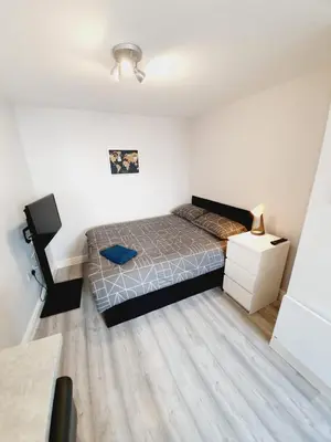a small bedroom with a bed and a night stand at Southend on Sea - Westcliff Studios - Great Location in Southend-on-Sea