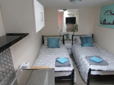 a small room with two beds and a tv at Independent two bed en-suite annex, close to city in Cambridge