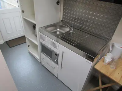 a small kitchen with a sink and a microwave at Independent two bed en-suite annex, close to city in Cambridge