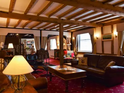 a living room with leather furniture and a table at The Old Bakery in Pulham Saint Mary Magdalene