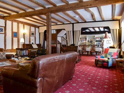 a living room with a leather couch and chairs at The Old Bakery in Pulham Saint Mary Magdalene