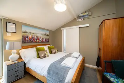 a bedroom with a bed and a large painting on the wall at The Bramley House Hotel in Chatteris